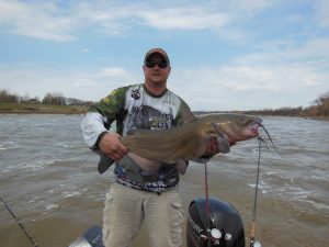 Fisherman on a river with a bit catfish catch